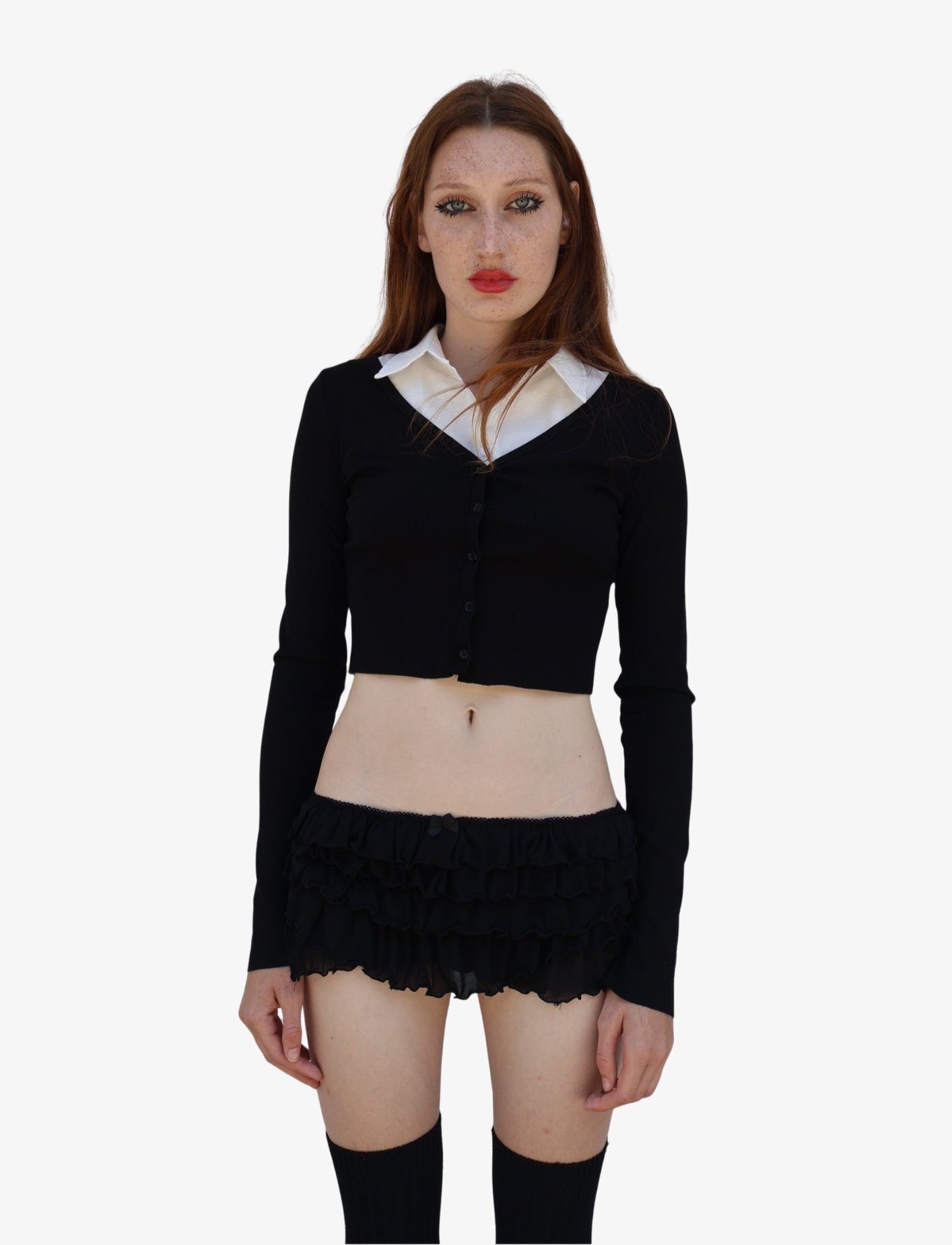 Woman wearing a black cardigan over a white shirt with a black skirt on a white background